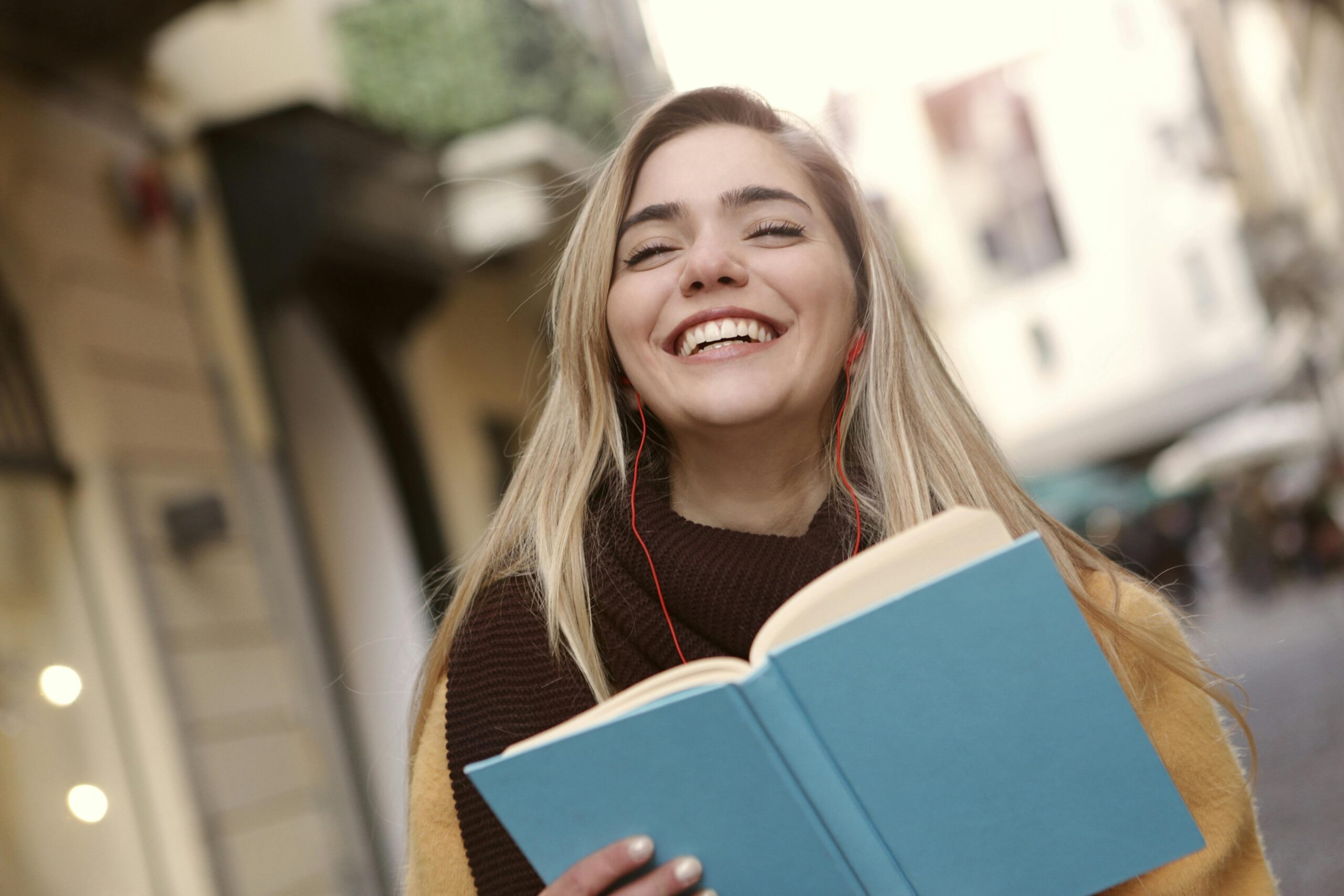 Woman smiling holding her newly purchased earbuds